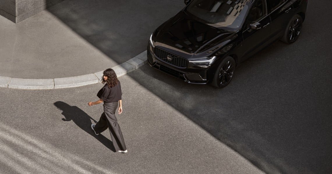 Volvo XC90 INSCRIPTION in Onyx Black metallic fährt über eine Kreuzung, Demonstration von IntelliSafe Surround